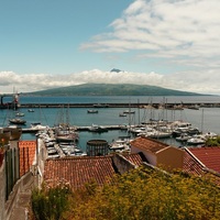 Ein Hafen auf den Azoren mit einem Vulkan im Hintergrund