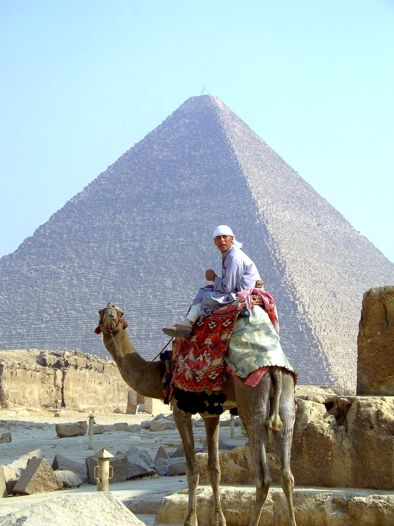 Kamel vor Pyramide Ein Junge, welcher auf einem Kamel sitzt, welches vor einer der Pyramiden von Gizeh steht