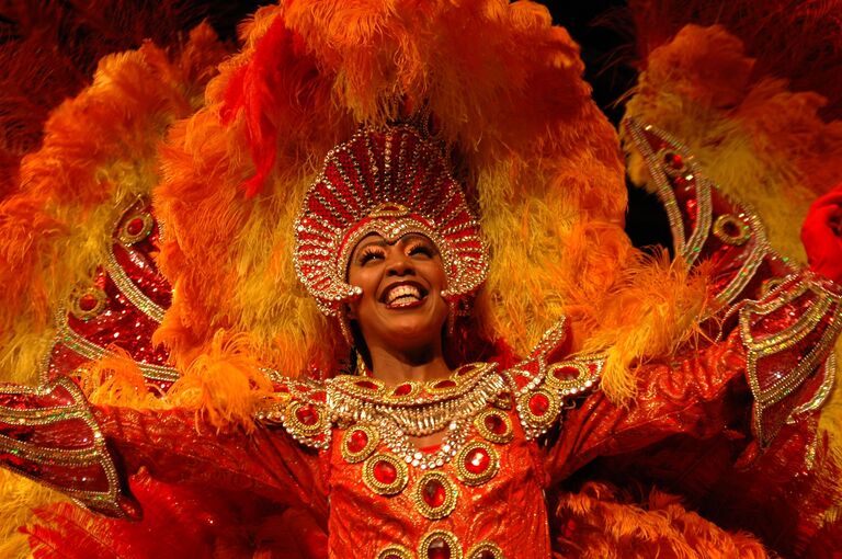 Karneval Brasilien Eine Frau aus Brasilien mit orangenem Karnevalskostüm
